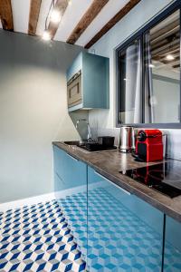 une cuisine avec des placards bleus et un comptoir dans l'établissement Cosy loft - plein centre d'Honfleur, à Honfleur
