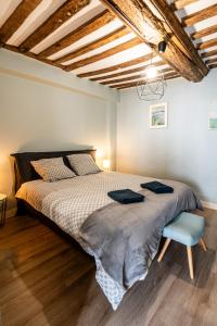 a bedroom with a large bed and a blue chair at Cosy loft - plein centre d'Honfleur in Honfleur