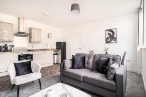 a living room with a couch and a kitchen at Modern 1 Bed Apartment in Central Wrexham in Wrexham +7 photos