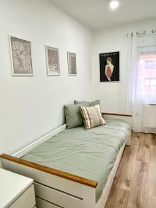 Bett in einem Zimmer mit weißen Wänden in der Unterkunft Recién reformado, céntrico, tranquilo y luminoso in Oviedo