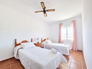 2 camas en una habitación con ventilador de techo en Apartamento en Calabardina - by Aloha Palma, en Calabardina