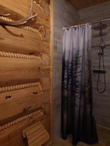 una ducha en una cabaña de madera con cortina en Domek u Heli, en Limanowa