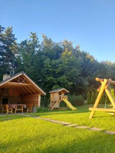 a yard with a playground and a log cabin at Domek u Heli in Limanowa
