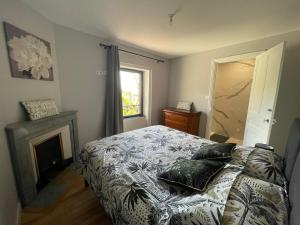 ChiroublesにあるChambres d'Hotes Le Panoramic Chiroubles Beaujolaisのベッドルーム1室(ベッド1台、暖炉、窓付)