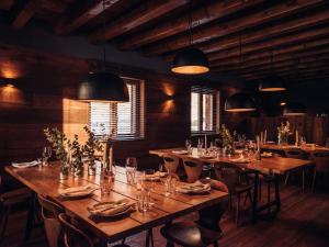 um restaurante com mesas e cadeiras de madeira e luzes em L´Ovella Negra Mountain Lodge em Canillo