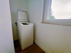 a small white refrigerator in a room with a window at Waldeck Rousseau - Séjour à Migennes in Migennes