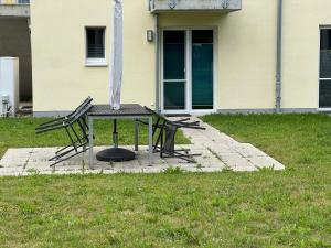 a table and two chairs in a yard with a house at Tamaris Resort in Graal-Müritz