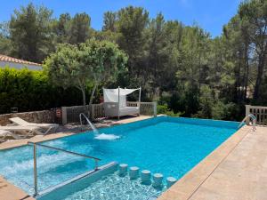 a swimming pool in a yard with a chair next to it at Apartamentos Pinosol in Santa Eularia des Riu