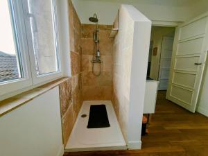 a bathroom with a shower with a bench in it at Waldeck Rousseau - Séjour à Migennes in Migennes