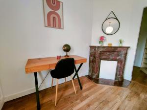 a desk with a chair in a room with a fireplace at Waldeck Rousseau - Séjour à Migennes in Migennes