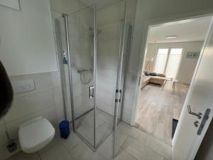a bathroom with a glass shower with a toilet at Tamaris Resort in Graal-Müritz +15 photos