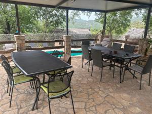 a patio with a table and chairs and an umbrella at Luxury house Ivan with 4 bedrooms in Divojevići