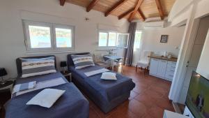 a room with two beds and a kitchen with windows at Apartments Valentina Tisno in Tisno