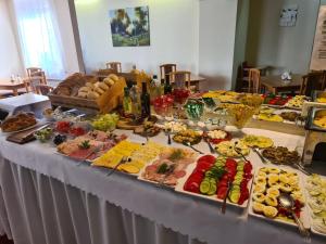 a table topped with lots of different types of food at Hotel Kolorowa in Karpacz