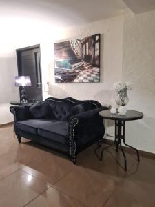 un divano nero in un soggiorno con tavolo di Hotel Kolorowa a Karpacz