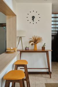 a table with two chairs and a clock on the wall at Ai House Nimman Chiang Mai in Chiang Mai