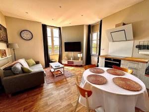 uma sala de estar com uma mesa e um sofá em Duplex - Place de parking privé em Orléans