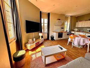 uma sala de estar com uma mesa e uma cozinha em Duplex - Place de parking privé em Orléans