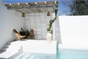a white patio with a pergola and a vase at Punta Mayia in Brisas de Zicatela +7 photos