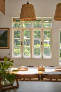 a dining room with a table and windows at Ai House Nimman Chiang Mai in Chiang Mai
