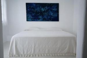 a table in a white room with a painting on the wall at Punta Mayia in Brisas de Zicatela