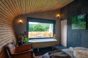 a large bathroom with a tub and a window at Two unique cabins wrapped in beautiful welsh scenery in Presteigne