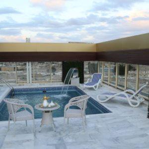 un patio con piscina, sillas y mesa en Areen Hotel Airport en Yeda
