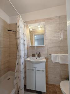 a bathroom with a sink and a shower curtain at Apartments & Rooms Samohod in Vodice