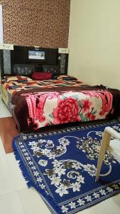 a bed with a colorful blanket on top of it at Shree Hatkeshwar Home Stay Ujjain in Ujjain
