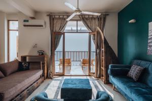 uma sala de estar com dois sofás e uma grande janela em Pili Pili Boho em Jambiani