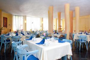 a restaurant with white tables and blue chairs at Hotel Georg in Witten