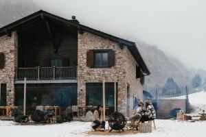 a group of people sitting in front of a building at L´Ovella Negra Mountain Lodge in Canillo