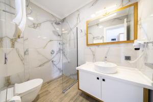 a bathroom with a toilet sink and a shower at Kalkan Beach Park Hotel in Kas