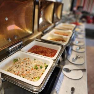 una línea de buffet con bandejas de comida en Centara Life Muscat Dunes Hotel en Mascate