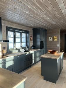 a kitchen with gray cabinets and a wooden ceiling at Ny flott høyfjellshytte på Geilo! 8 min til Kikut in Geilo
