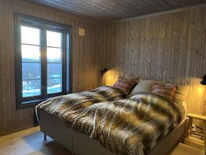 a bedroom with a large bed with a window at Ny flott høyfjellshytte på Geilo! 8 min til Kikut in Geilo