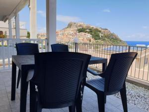 a table and chairs on a balcony with a view of the ocean at Samy house in Castelsardo