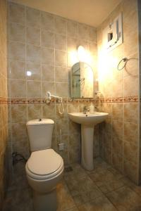 La salle de bains est pourvue de toilettes et d'un lavabo. dans l'établissement Bonapart Hotel, à Çeşme