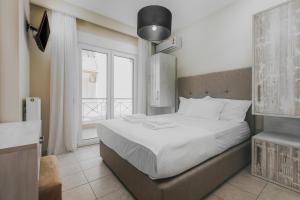 ケラモティにあるInside Apartmentの白いシーツと窓のあるベッドのある寝室