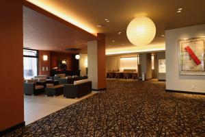 a lobby of a hotel with couches and a chandelier at Dogo Onsen Yachiyo 道後温泉八千代 in Matsuyama