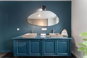 uma casa de banho azul com 2 lavatórios e um espelho em Fall Eighteen by Romy&Travis em Bruges mais 37 fotografias