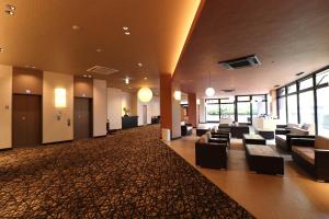 a large lobby with couches and tables and windows at Dogo Onsen Yachiyo 道後温泉八千代 in Matsuyama