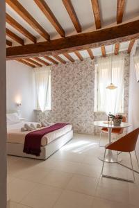Schlafzimmer mit einem Bett und einem Tisch in der Unterkunft GLAM PARMA in Parma