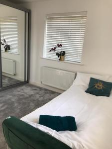 - une chambre avec un lit blanc et un miroir dans l'établissement Broxbourne apartment (2 bed), à Broxbourne