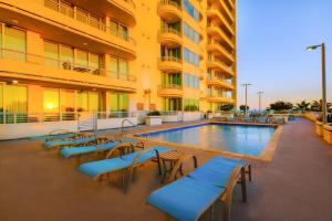 un hotel con piscina y sillas y un edificio en Ocean Club 406 en Biloxi