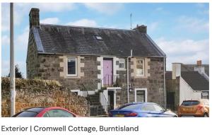 a stone house with a pink door and cars parked in front at Burntisland - Stay4 - SeaSide - Sea Views in Burntisland