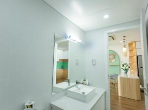 bagno bianco con lavandino e specchio di Green Diamond Homestay Hạ Long a Ha Long