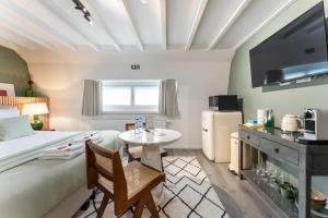 um quarto com uma cama, uma mesa e uma televisão em Fall Eighteen by Romy&Travis em Bruges
