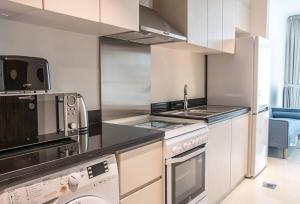a kitchen with a sink and a stove top oven at AWS Homes - Modern Living in Top Location in Dubai