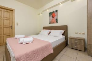 a bedroom with two beds with pink sheets at Villa Roula in Koinyra